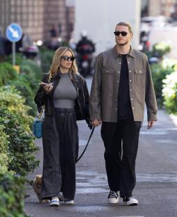 a man and woman walking down a street holding hands