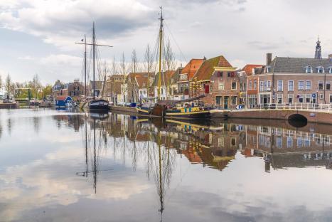 Weesp harbor with boats and historic buildings reflected in the water.