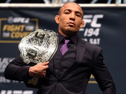 Jose Aldo of Brazil holding a UFC championship belt.