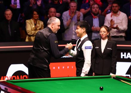 Xintong Zhao and Mark Williams shaking hands after a snooker match.