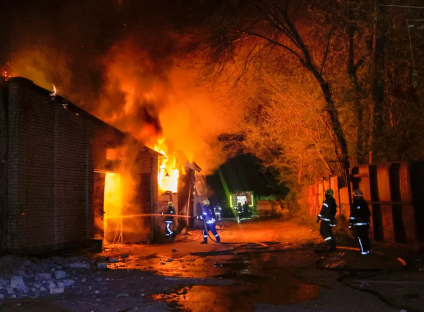 Firefighters battling a large building fire at night.