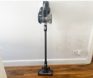 Vax cordless vacuum cleaner standing on a wooden floor.
