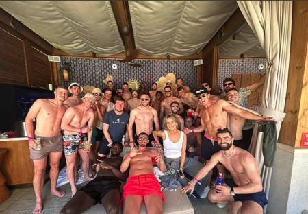 Large group of shirtless men and one woman at a pool party.