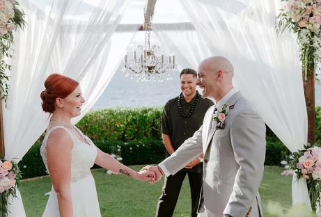 Bride and groom holding hands at their wedding ceremony.
