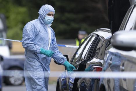 Forensic officer examining a car at a counter-terrorism raid.