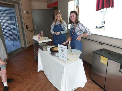 Two women making crepes at a crepe stand.