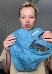 Person holding up a blue sports bra.