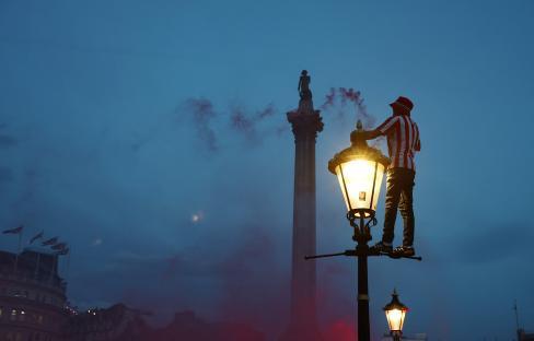 Sunderland fan on a lamppost in Trafalgar Square, lighting a flare.