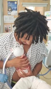 Two parents holding their newborn babies in a hospital.