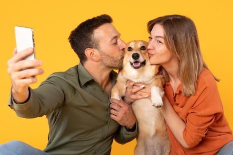 Couple taking a selfie with their corgi dog.