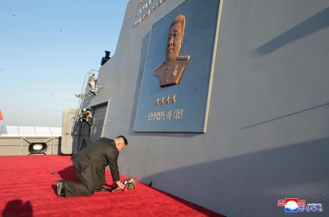 Kim Jong Un laying flowers at a memorial on a new warship.