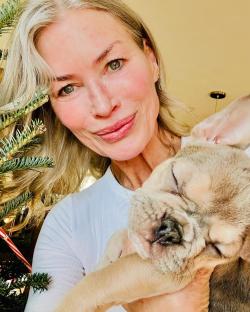 CarrÃ© Otis holding a French bulldog puppy.