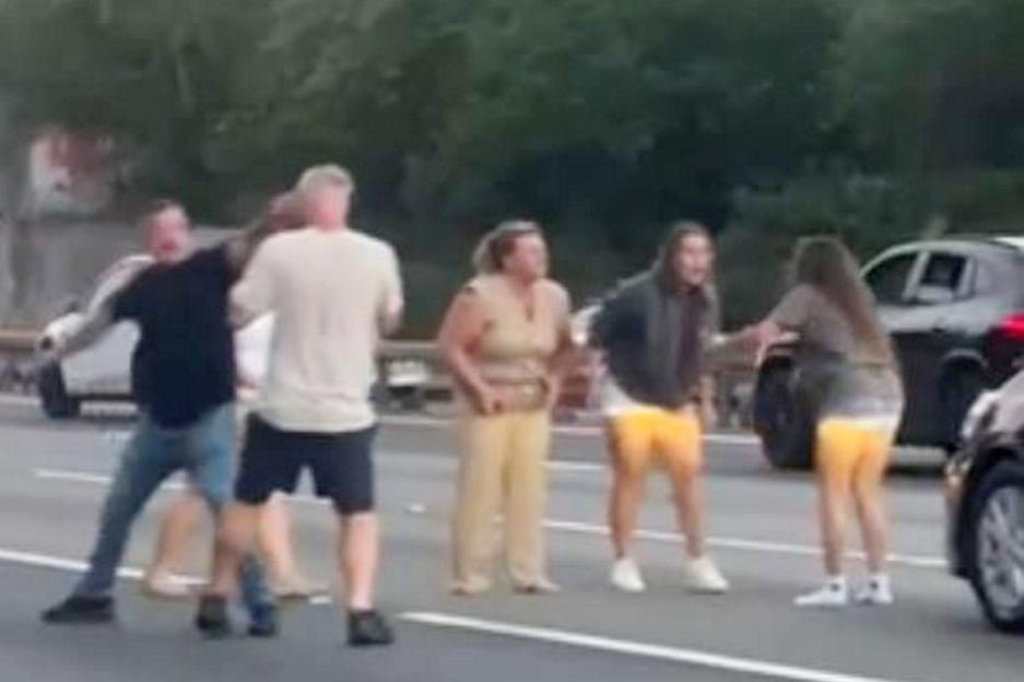 A woman was seen dragging another motorist out of their car by their hair - as six people were captured on camera having a "road rage brawl" on a motorway. The group of people can be seen throwing punches at one another before a woman drags another woman out of a car by her hair. According to a witness the fight involved occupants of a white Audi A3 and a larger black car on the M25. Two men are seen grappling and swinging wild punches at each other as stunned motorists drive past. The fight took place yesterday evening (07/09) on the southbound lanes of the motorway, near the J12 Thorpe interchange with the M3.