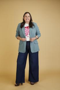 Woman in teal blazer and wide-leg jeans.