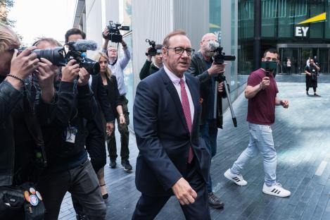 Kevin Spacey leaving Southwark Crown Court, surrounded by photographers and videographers.