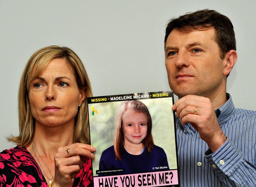 Gerry and Kate McCann hold an age-progression image of their missing daughter, Madeleine, at a press conference.