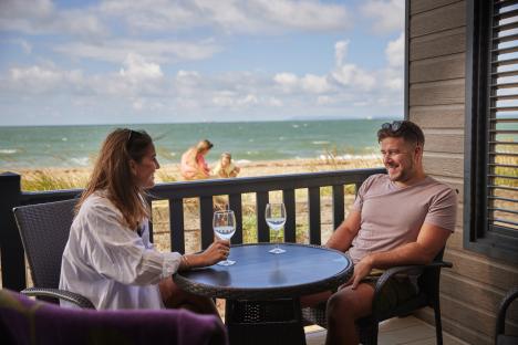 Couple relaxing on a patio overlooking the ocean.