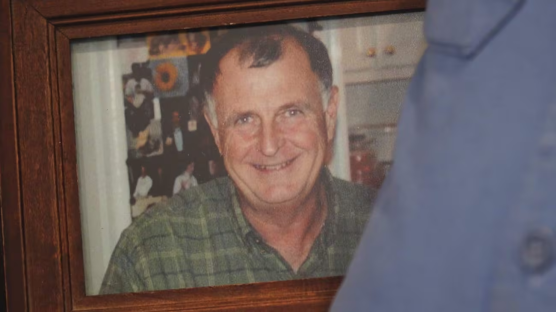 Framed photo of a smiling man in a plaid shirt.