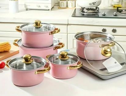 Pink stainless steel cookware set with glass lids.