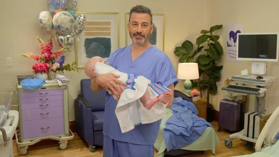 Jimmy Kimmel holding a newborn baby.