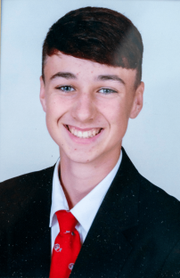 Portrait of a smiling young man in a suit and red tie.
