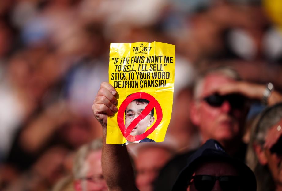 Sheffield Wednesday fan holding a sign protesting club owner Dejphon Chansiri.
