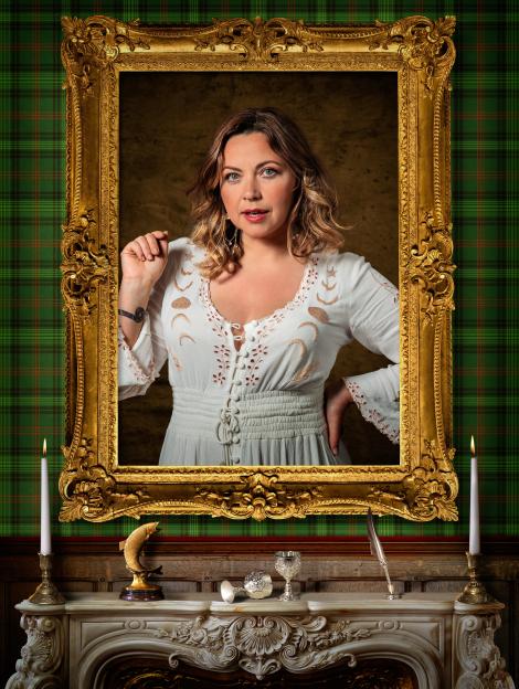 Charlotte Church in a white dress, framed by a gold baroque picture frame, set against a green plaid wallpaper.