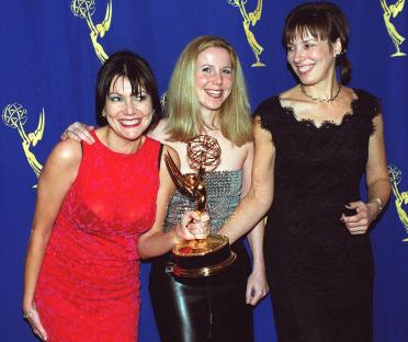 Fiona Allen, Sally Phillips, and Victoria Pile holding an Emmy Award.