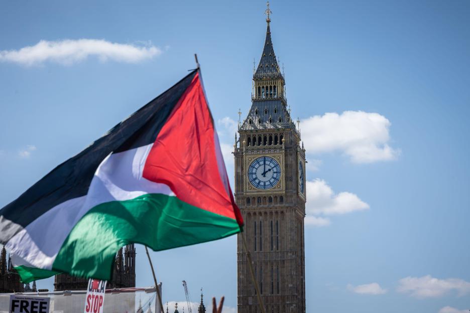 A Palestinian flag waving in front of the Elizabeth Tower (Big Ben) in London during a protest.