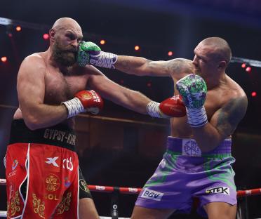 Oleksandr Usyk landing a punch on Tyson Fury during a boxing match.