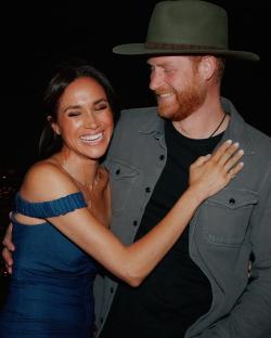 Meghan Markle and Prince Harry smiling at a BeyoncÃ© concert.