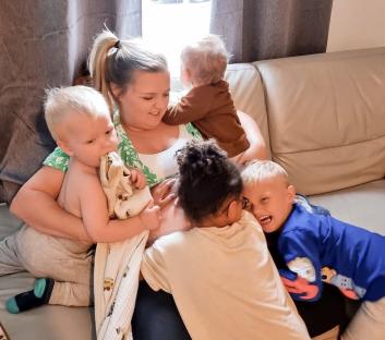 Woman breastfeeding her children on a couch.