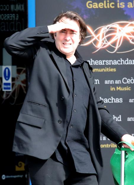 Jonathan Ross shields his eyes from the sun at Inverness airport.