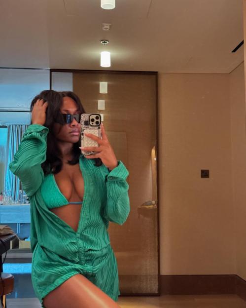 Tolami Benson in a green pleated cover-up and bikini top.