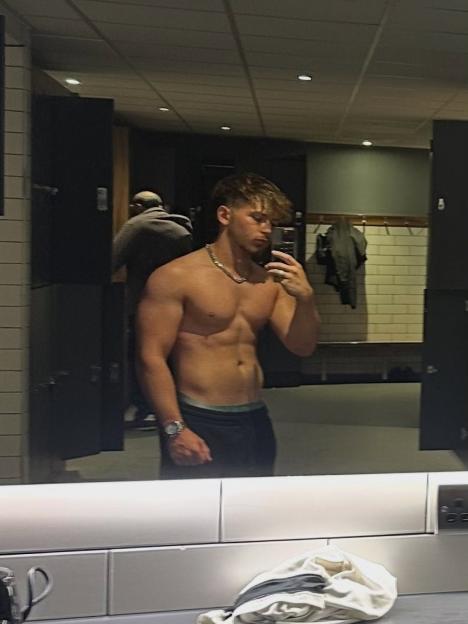 Selfie of a shirtless man in a gym locker room.