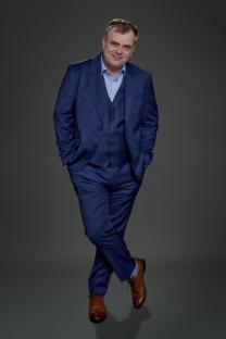 Portrait of Simon Gregson in a blue suit.