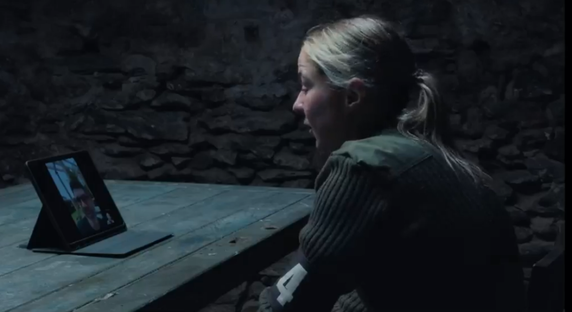Woman on a video call in a dark room.