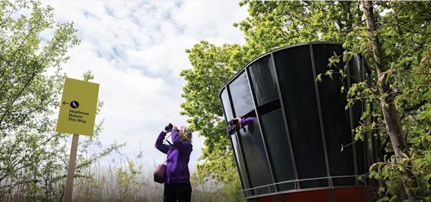 A woman birdwatching at Heathrow Airport's Causeway Nature Reserve.