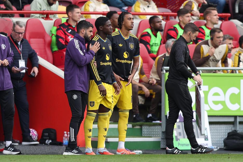Manchester United's Kobbie Mainoo and Leny Yoro wait to come on as substitutes during the Brentford FC v Manchester United FC Premier League Match.