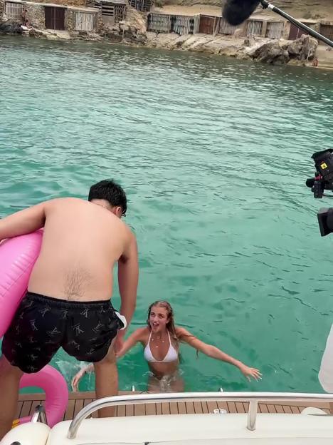 Woman entering the water from a boat.