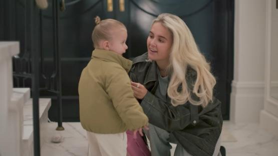 A woman and a toddler girl interacting.