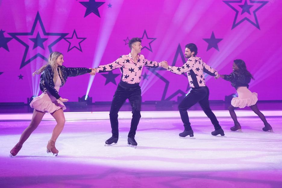 Four ice skaters performing on a rink.