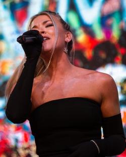 Woman singing into a microphone.