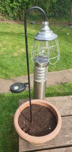 Solar-powered garden light in a plant pot.