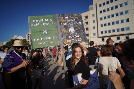 Protestors holding signs at an anti-tourism demonstration.