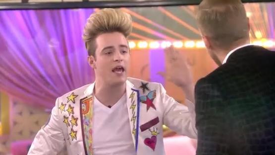 A man in a brightly colored jacket argues with another man.