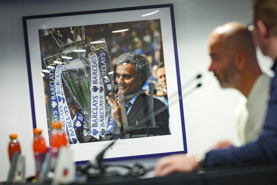 A framed photo of Jose Mourinho holding the Barclays Premier League trophy, with Enzo Maresca in the foreground.