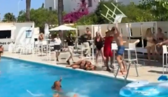 Shocking moment female tourist is bashed in the head with a CHAIR while another topples into pool in Ibiza hotel brawl