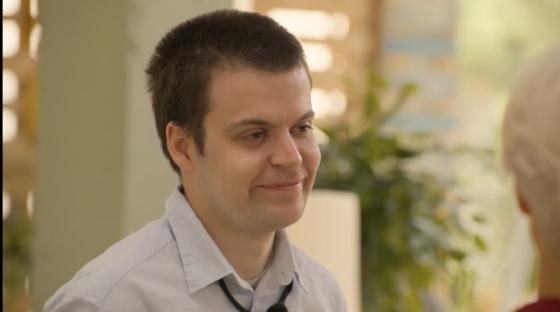 Man smiling and looking off to the side.
