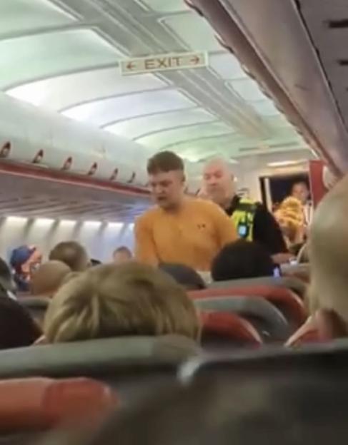 Photo of a man being arrested on a plane.